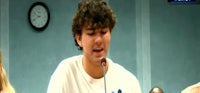 a young man is speaking into a microphone